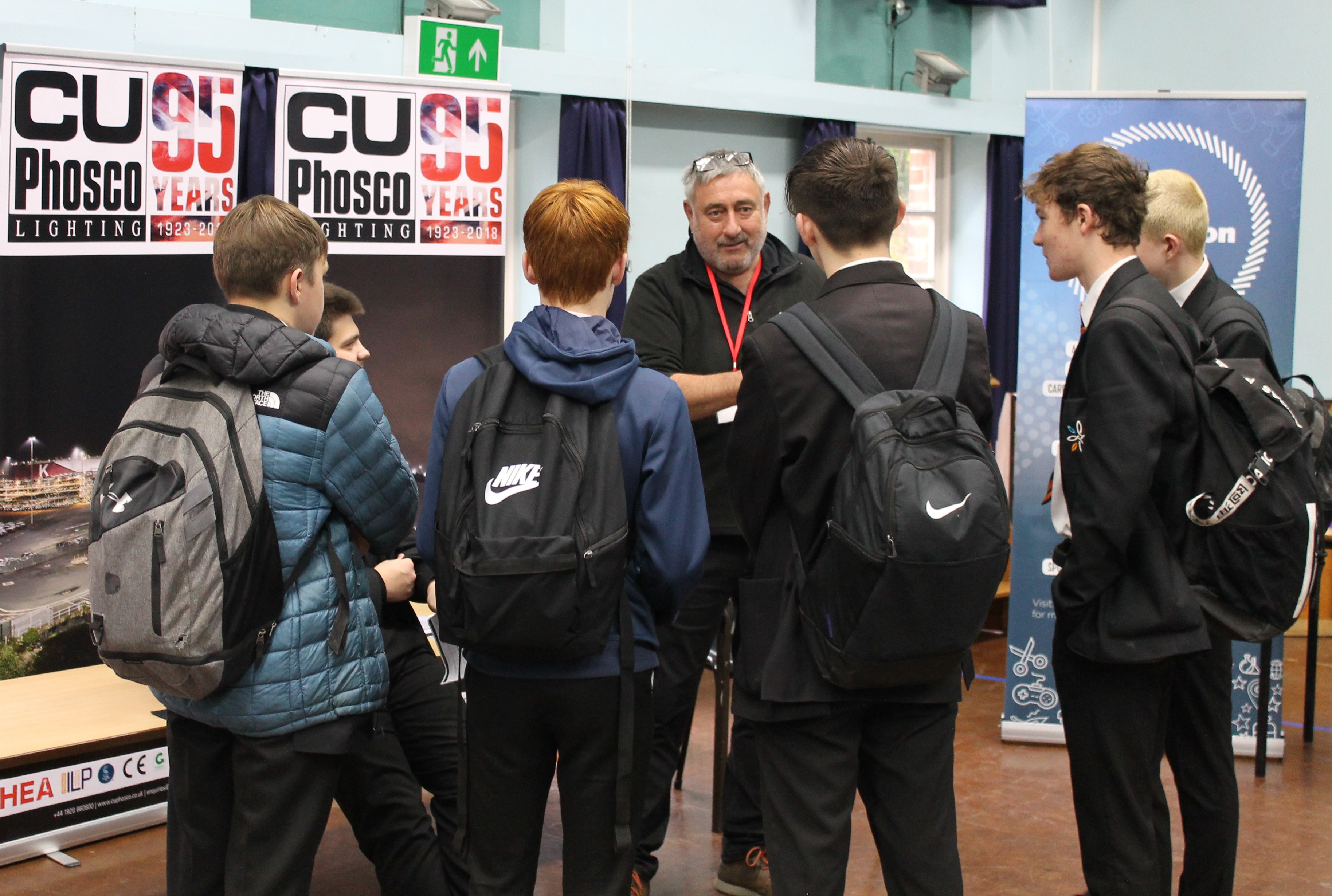 Pupils gathered around C U Phosco's stall engaged in conversation.