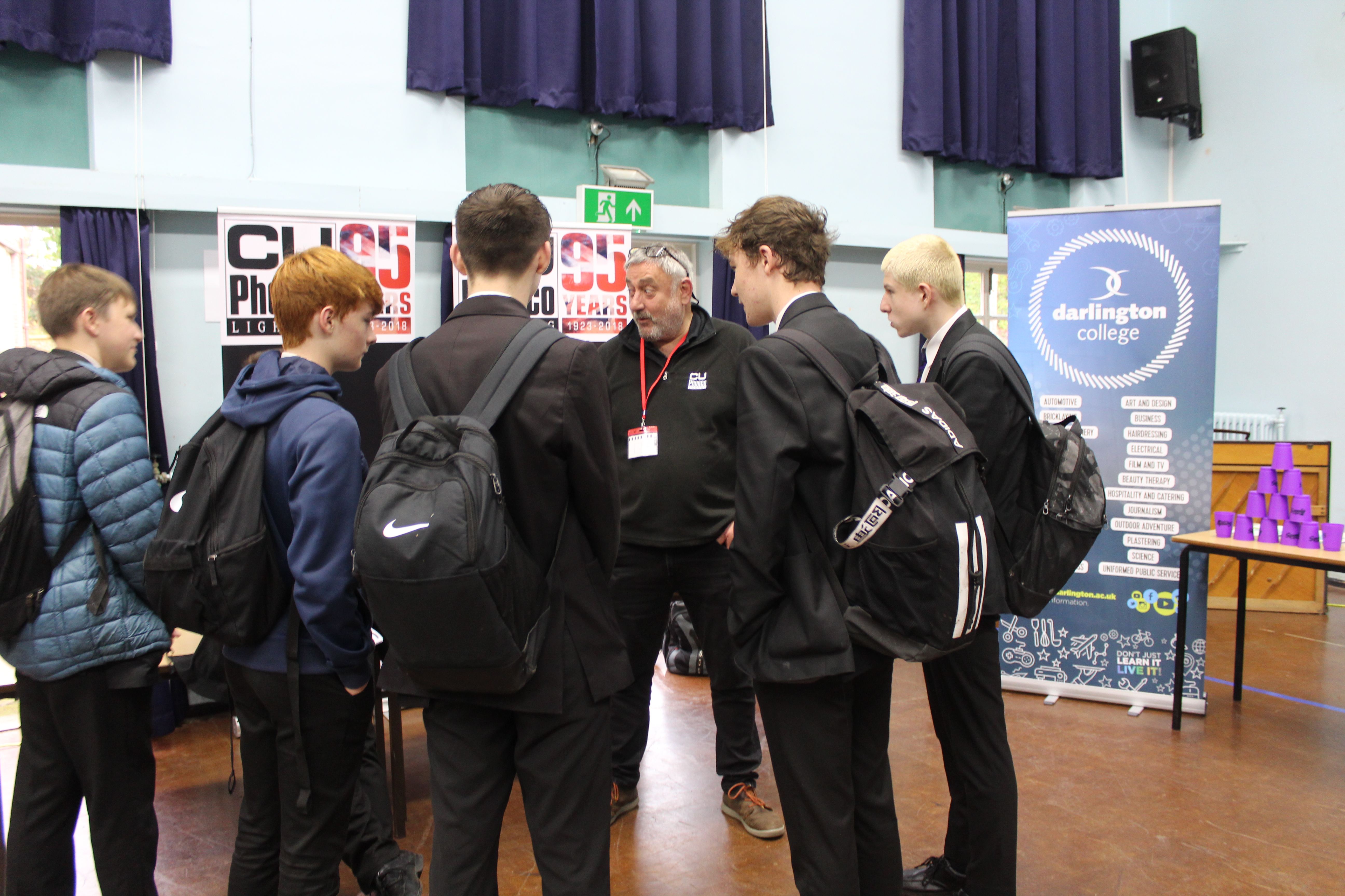 Pupils gathered around C U Phosco's stall engaged in conversation.